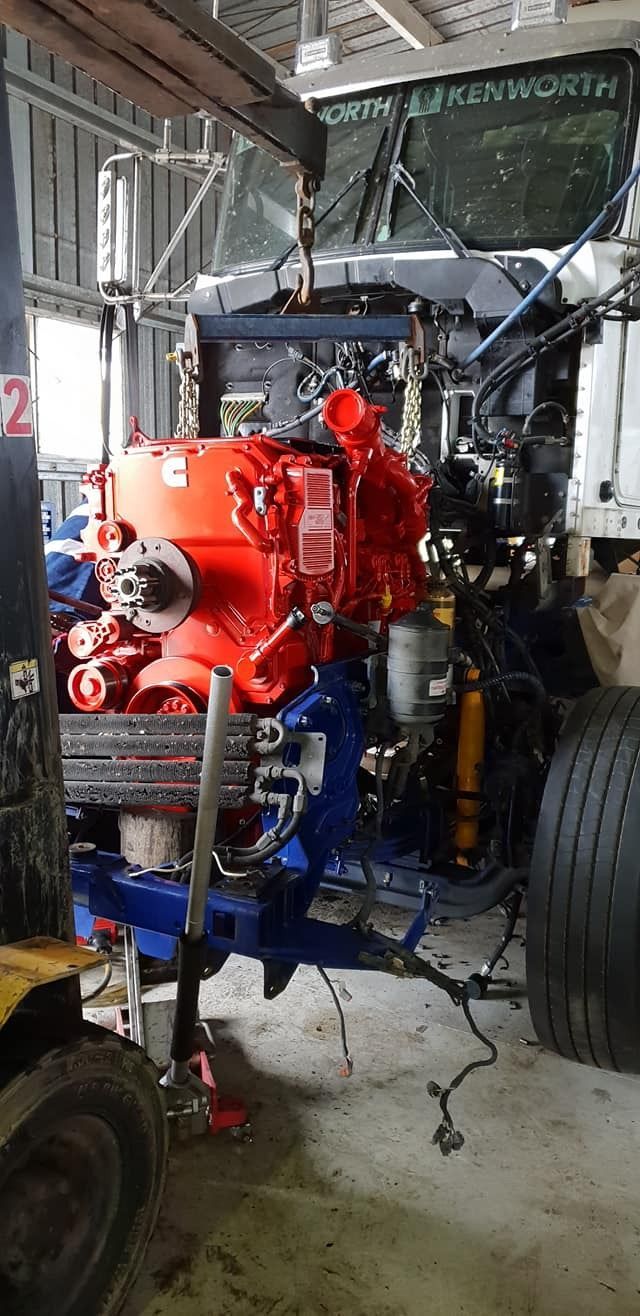 A Large Red Engine Is Sitting On Top Of A Truck In A Garage — All Engine Repairs in South Murwillumbah, NSW