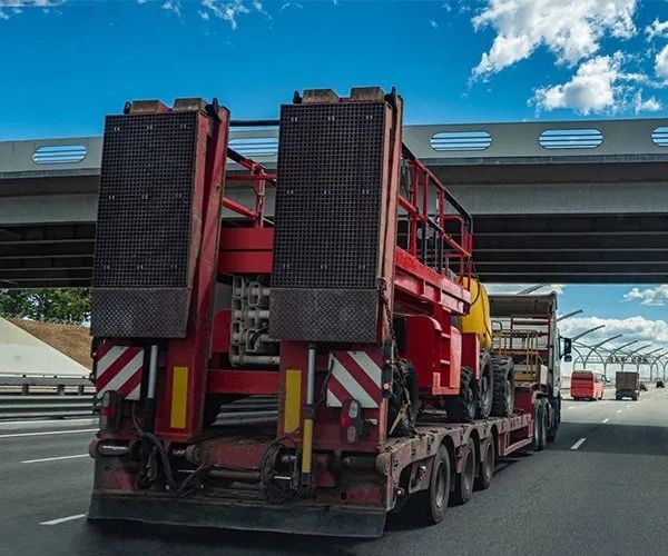 A Red Semi Truck Is Driving Down A Highway Under A Bridge — All Engine Repairs in South Murwillumbah, NSW