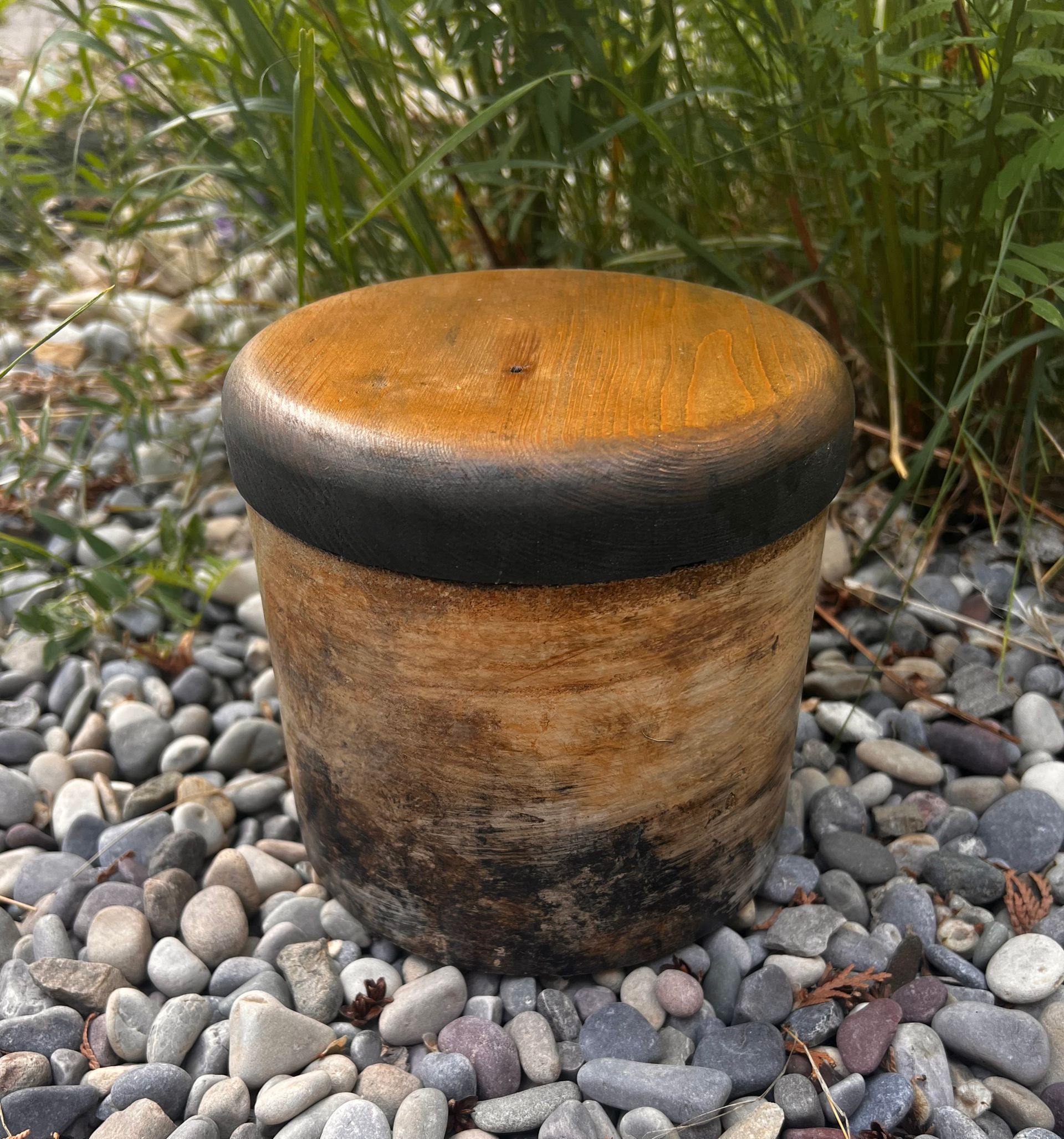 A wooden stool is sitting on top of a pile of rocks.