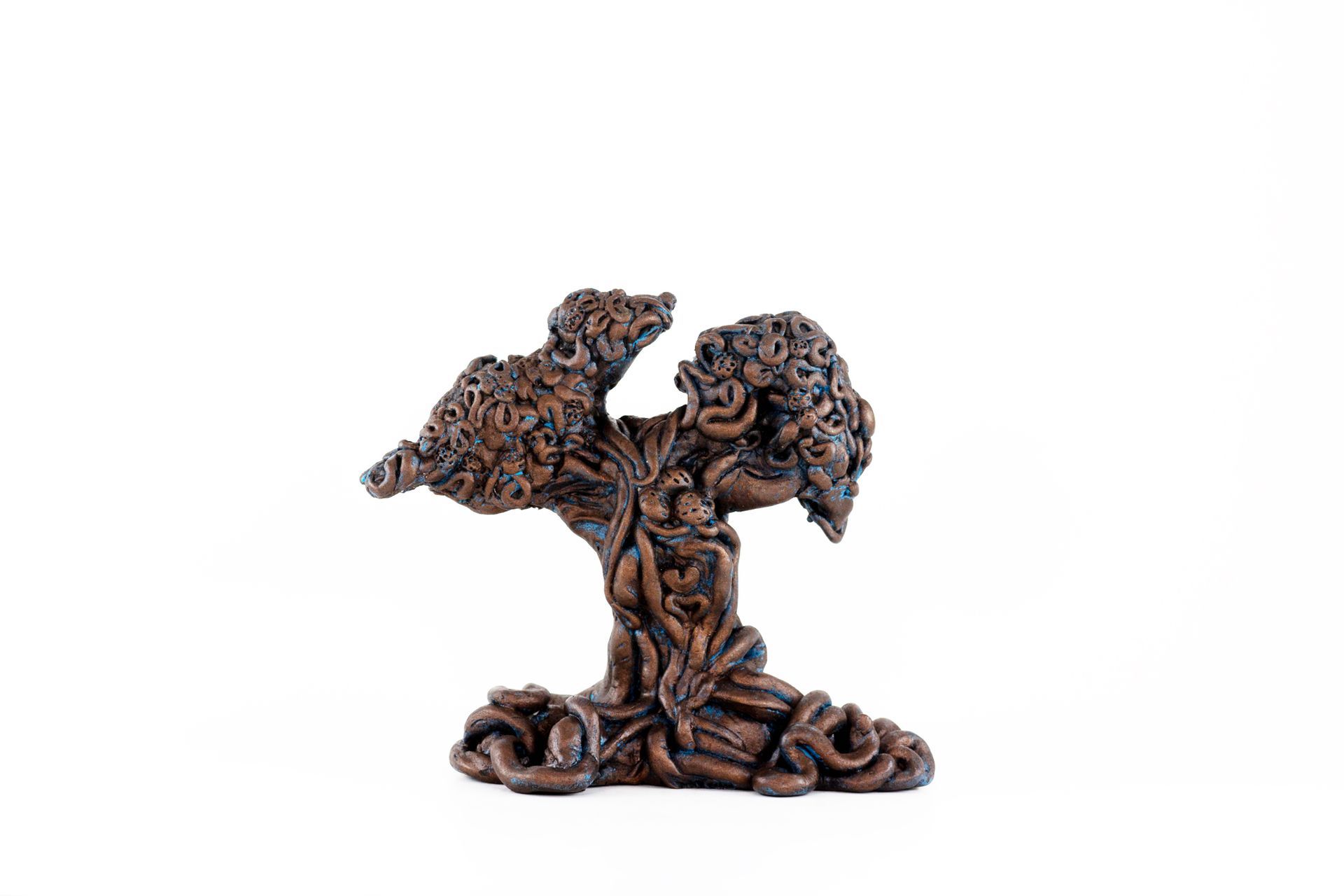 A statue of a tree with a face on it on a white background.