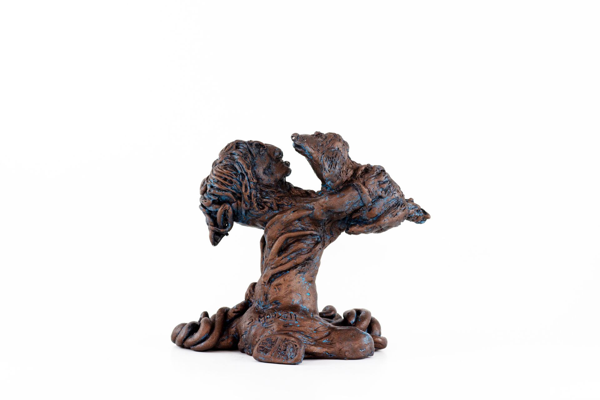 A small wooden sculpture of a tree on a white background.