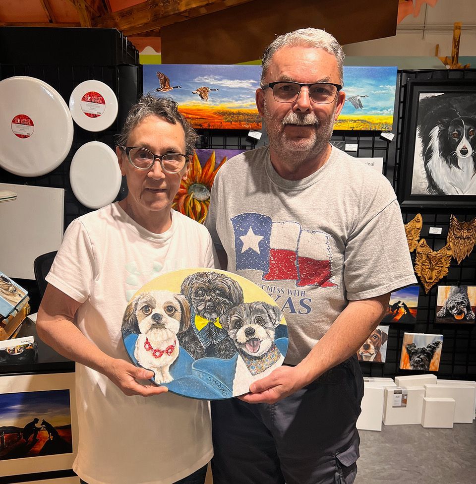 A man and a woman are holding a plate with two dogs on it