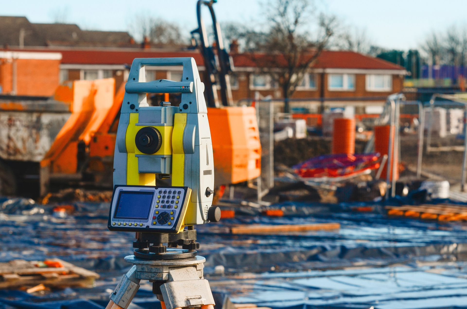 Land surveyors equipment theodolite or total positioning station set on tripod on construction site. Land surveyors equipment theodolite or total positioning station set on tripod on construction site.