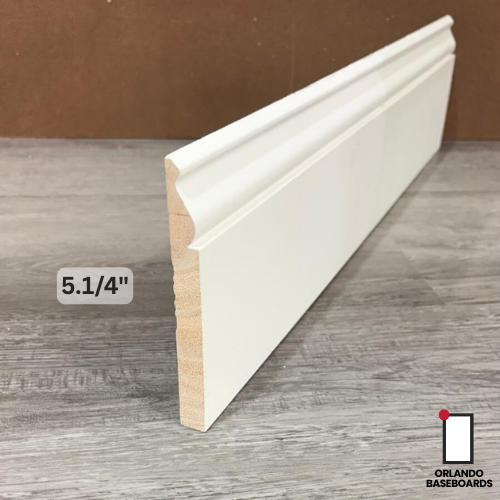 White baseboard trim, 5.25 inches tall, against a wood grain floor and brown wall. WM 738