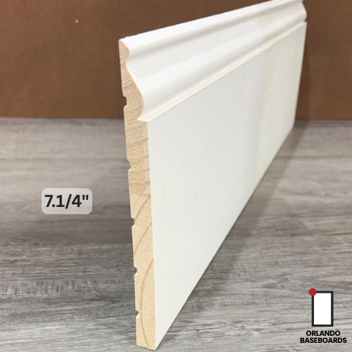 White baseboard trim, 7.25 inches tall, against a wood grain floor and brown wall. WM 738