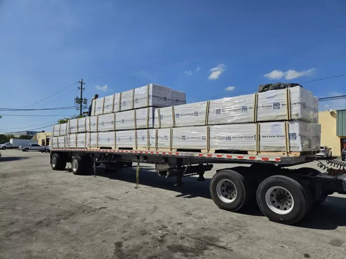 A semi truck filled with boxes is parked in a parking lot.