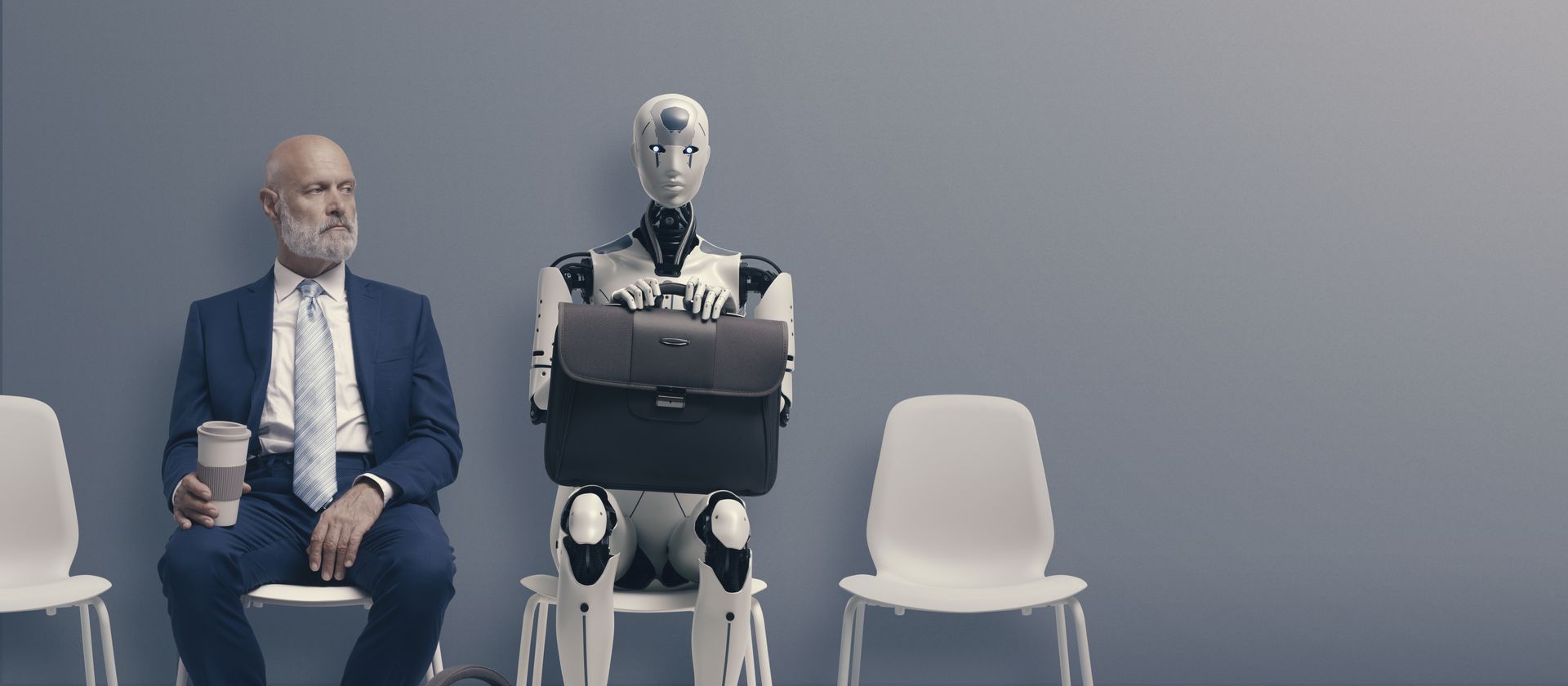 A man in a suit and tie is sitting next to a robot holding a briefcase.