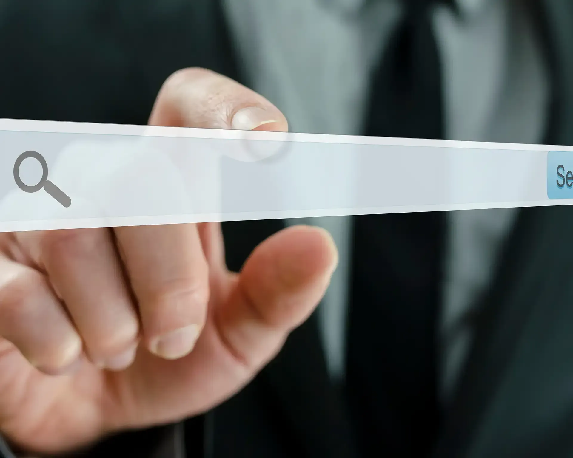 Die Hand einer Person zeigt auf eine Suchleiste mit einem Lupensymbol; blaue Schaltfläche „Suchen“ sichtbar.