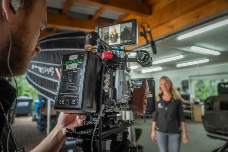 Ein Videograf filmt eine Frau mit einer professionellen Kamera für eine Videoproduktion.