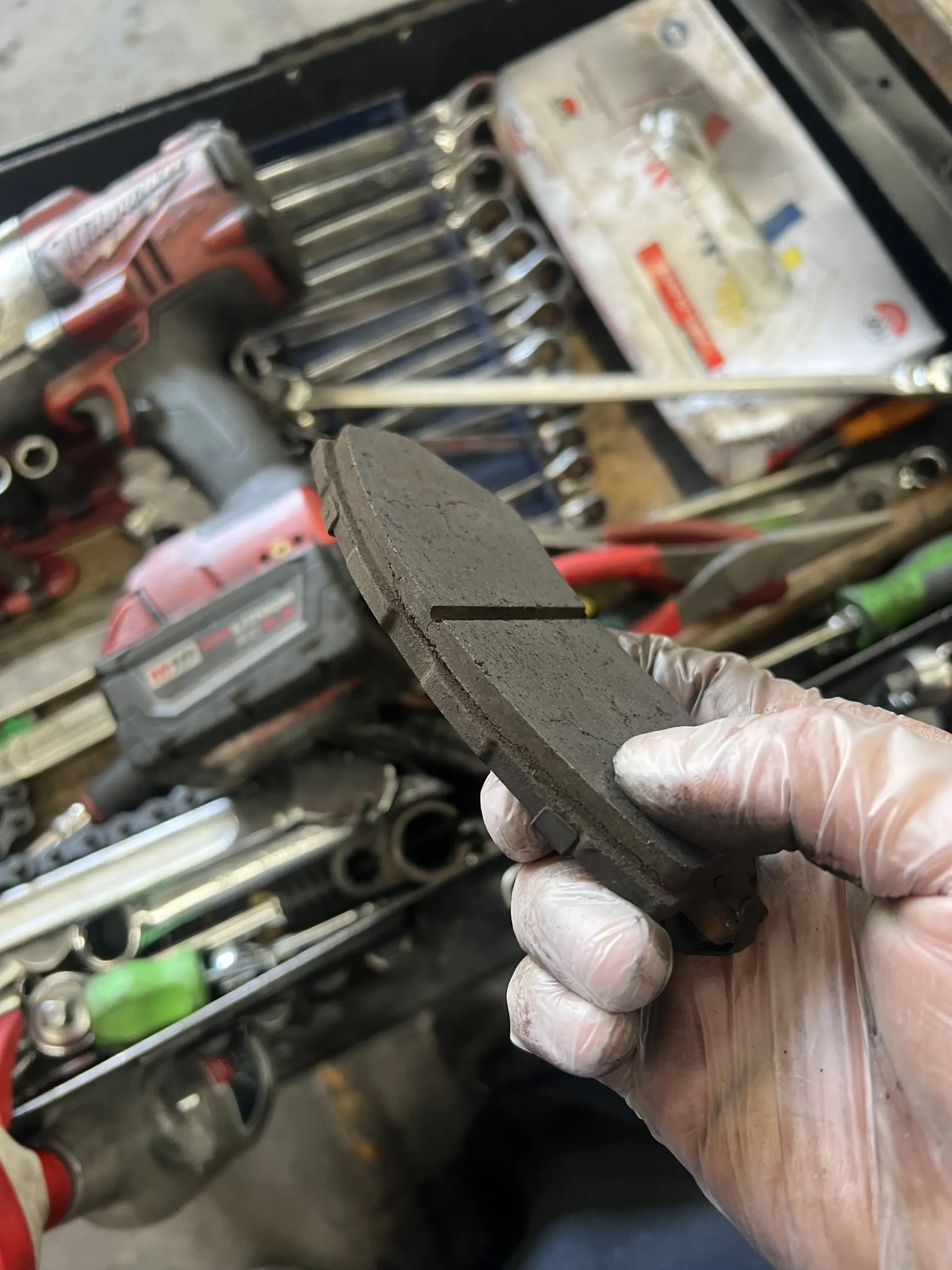 Hands of a mechanic holding a break pad