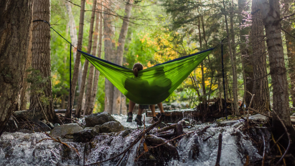 Couple sitting in a hammock over a river