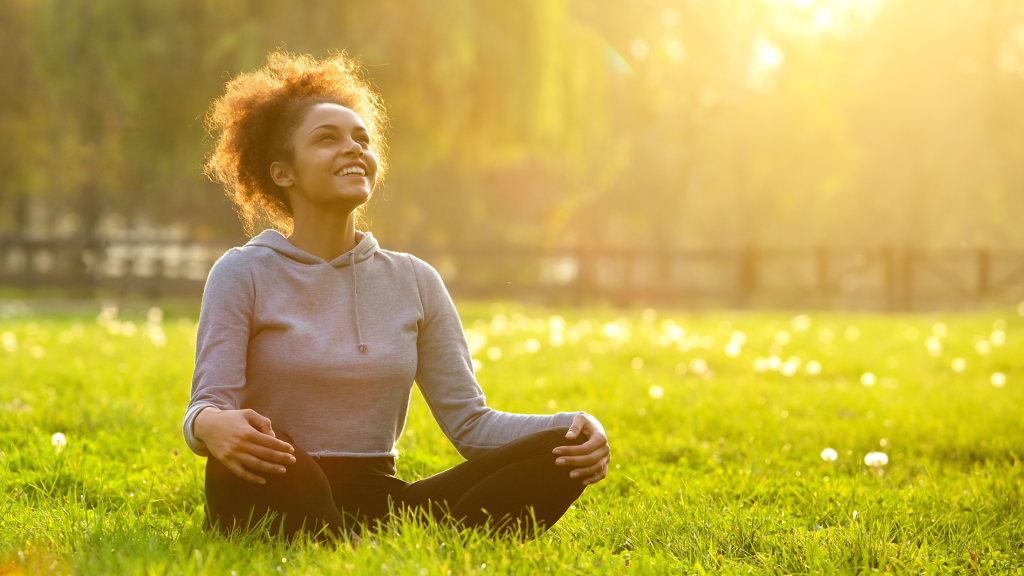 Black woman sitting peacefully in the grass