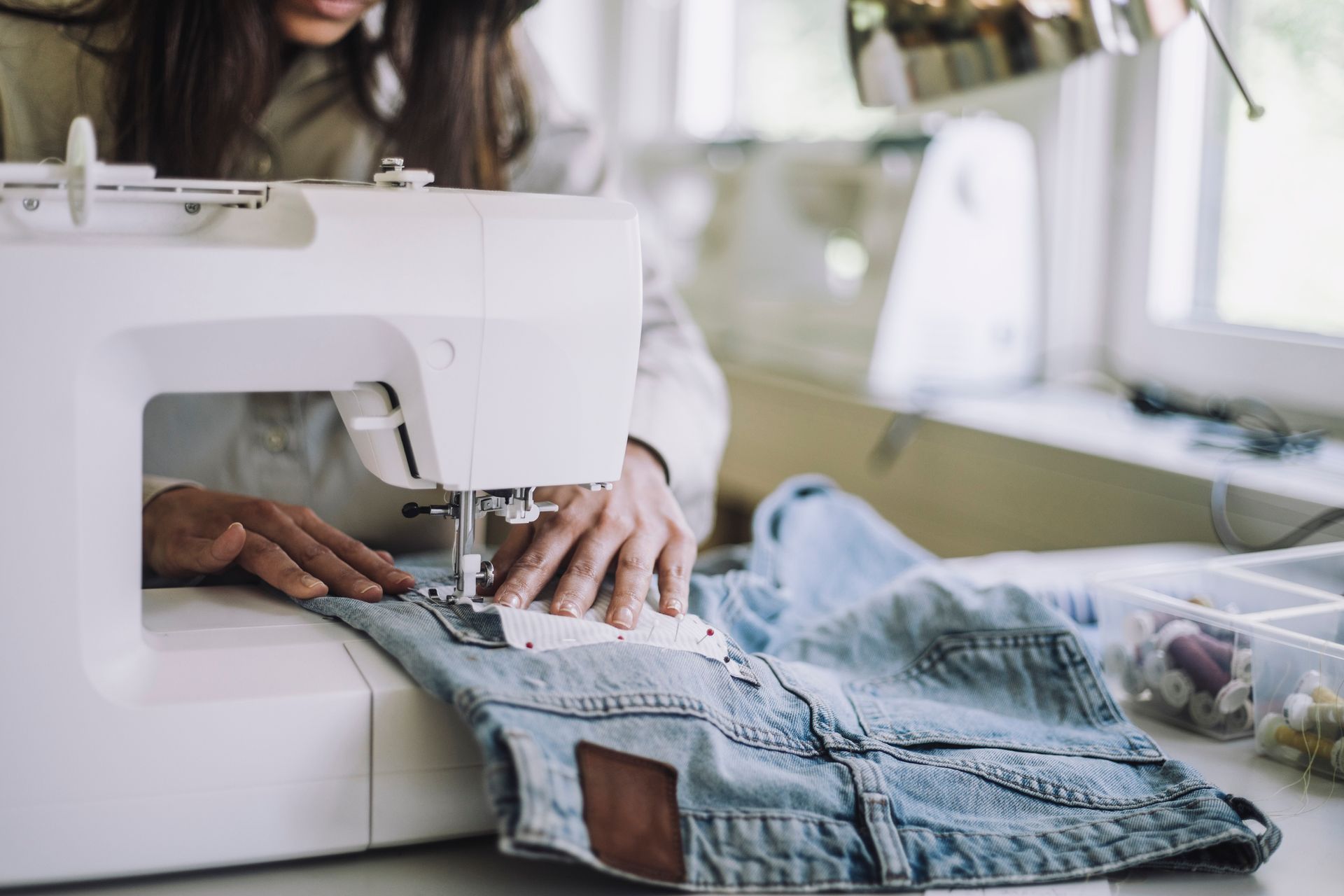 A Woman Is Sewing A Pair Of Jeans On A Sewing Machine | Clarksville, TN | Snyder’s Tailoring