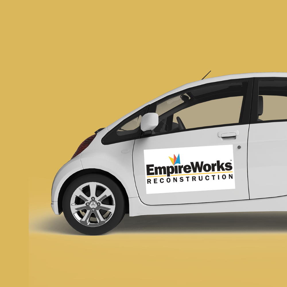A white car with a sign on the door that says empire works