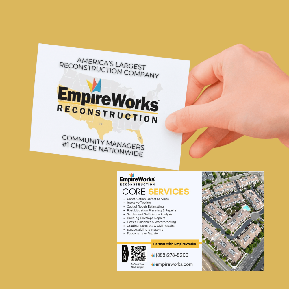 A hand is holding a business card for empire works general contracting