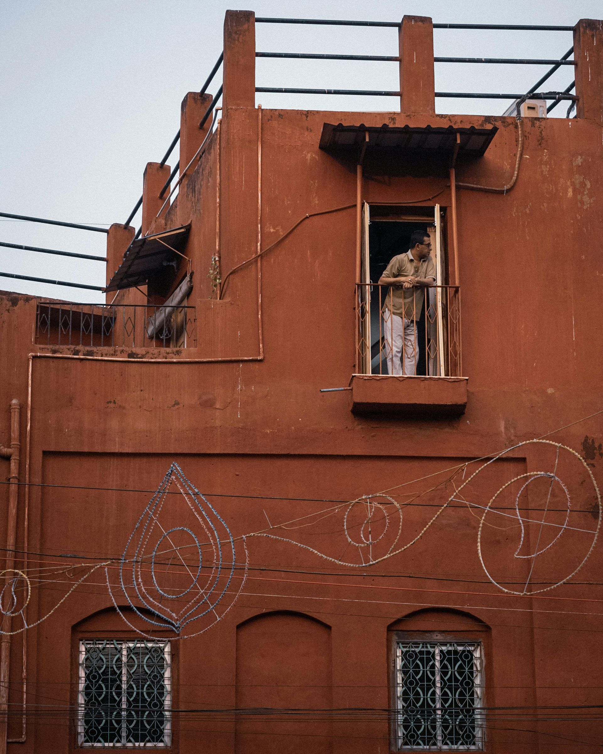 A brick building with a balcony on the top of it