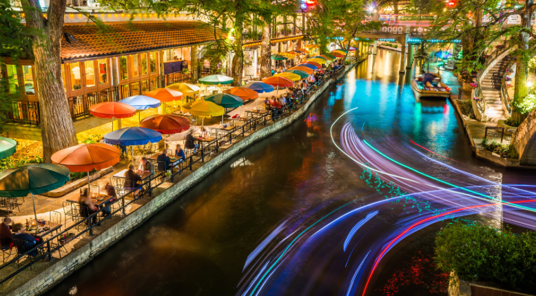 A long exposure photo of a river with umbrellas and lights.