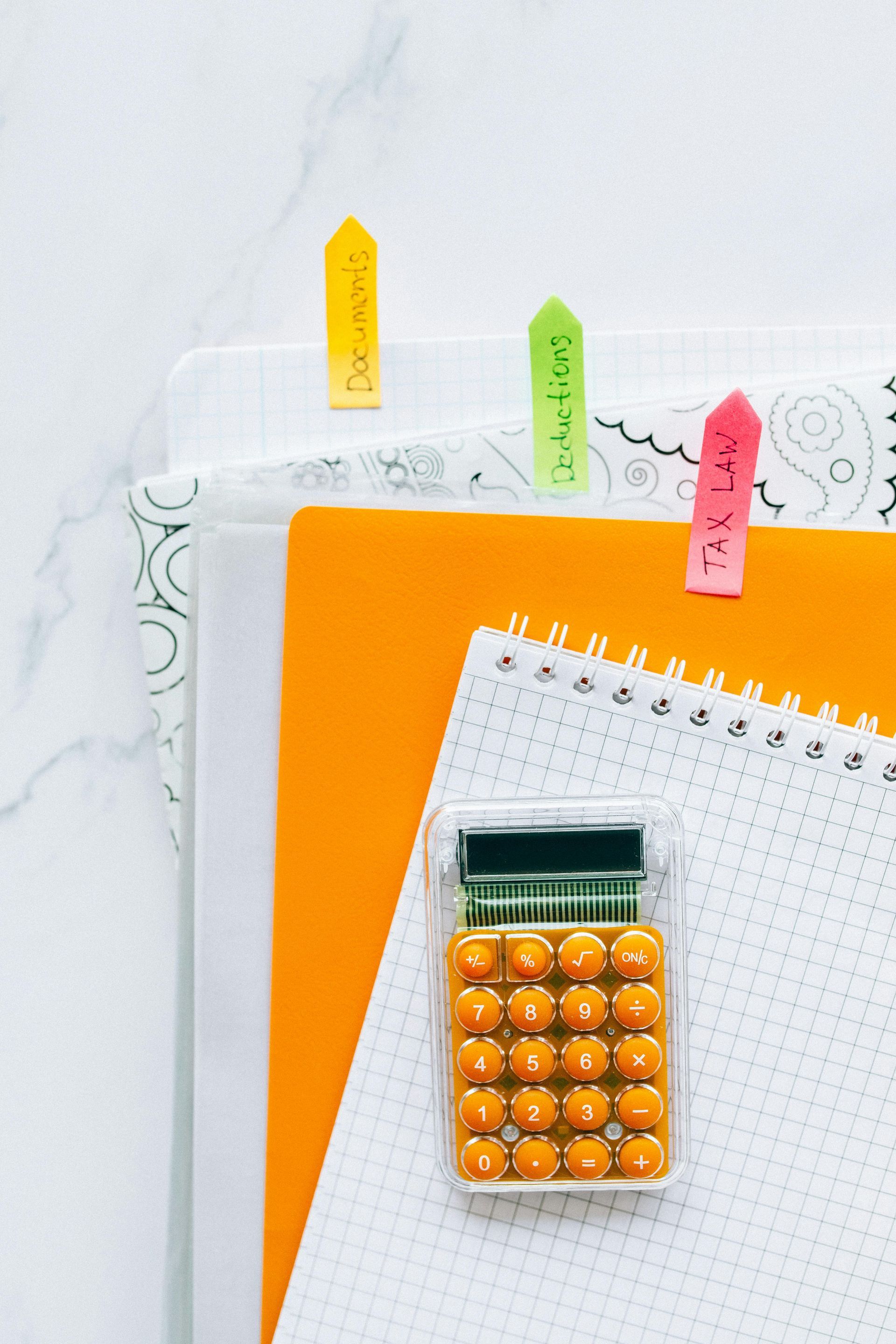 A calculator is sitting on top of a notebook.