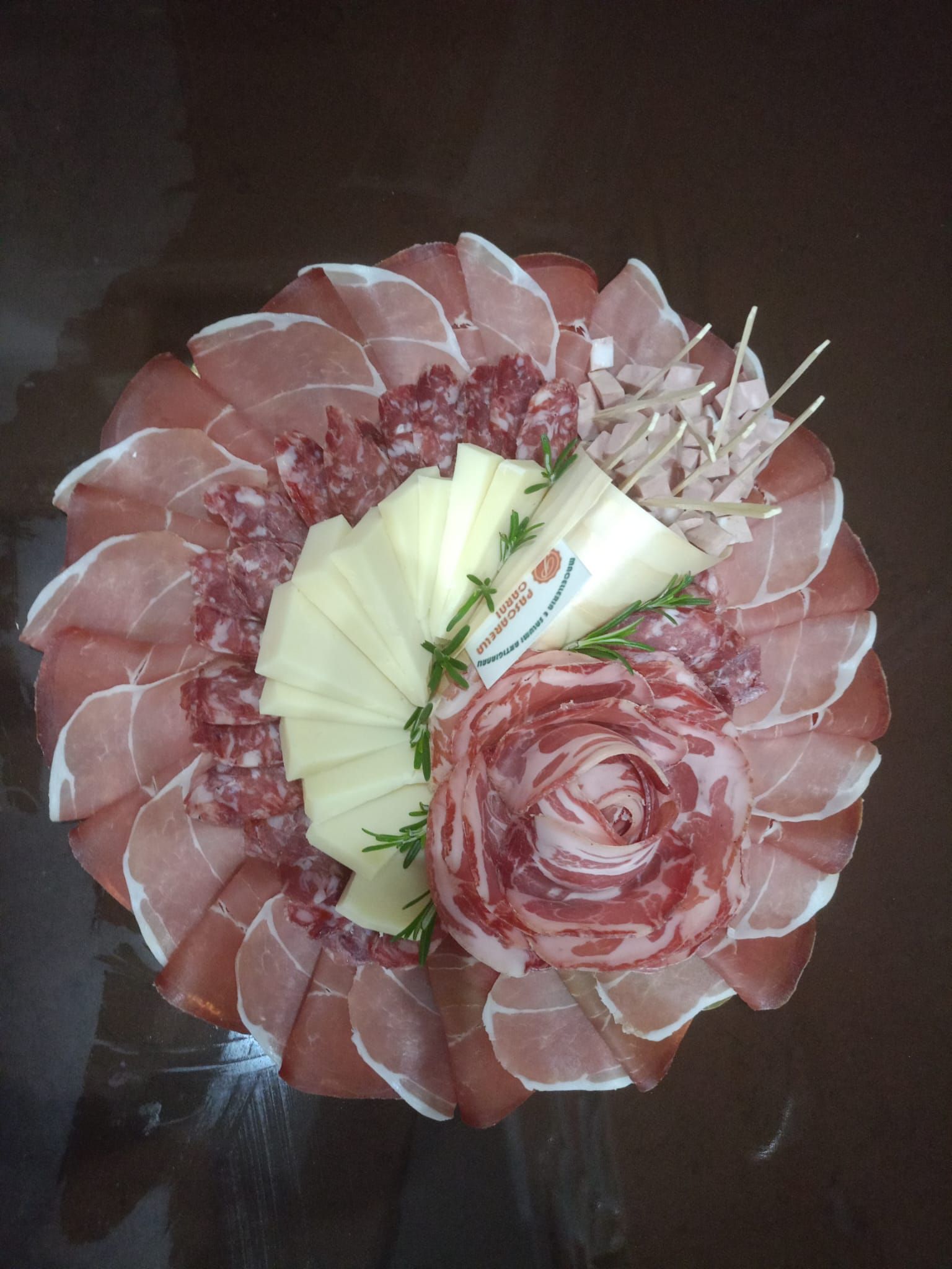 Bouquet di fiori di carta rosa e crema con petali sovrapposti su una superficie scura