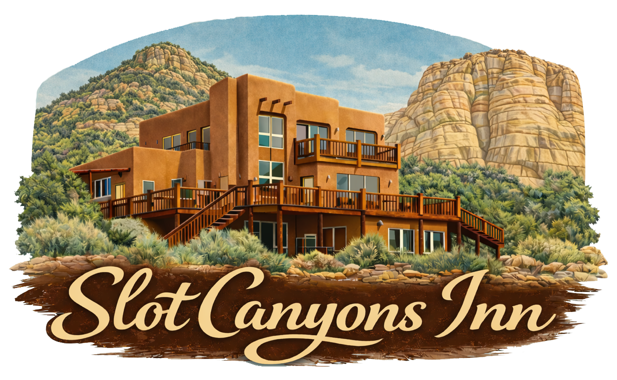 A tan, multi-level adobe building nestled among desert hills and red rock cliffs, with the text 