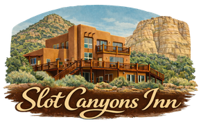 A tan, multi-level adobe building nestled among desert hills and red rock cliffs, with the text 