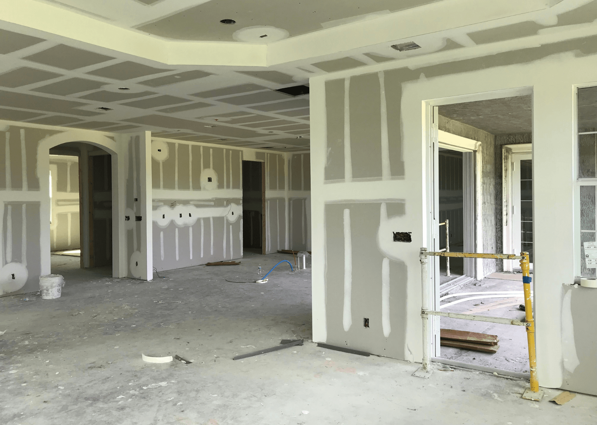 Interior of a house under construction, drywall installed on walls and ceiling; unfinished.