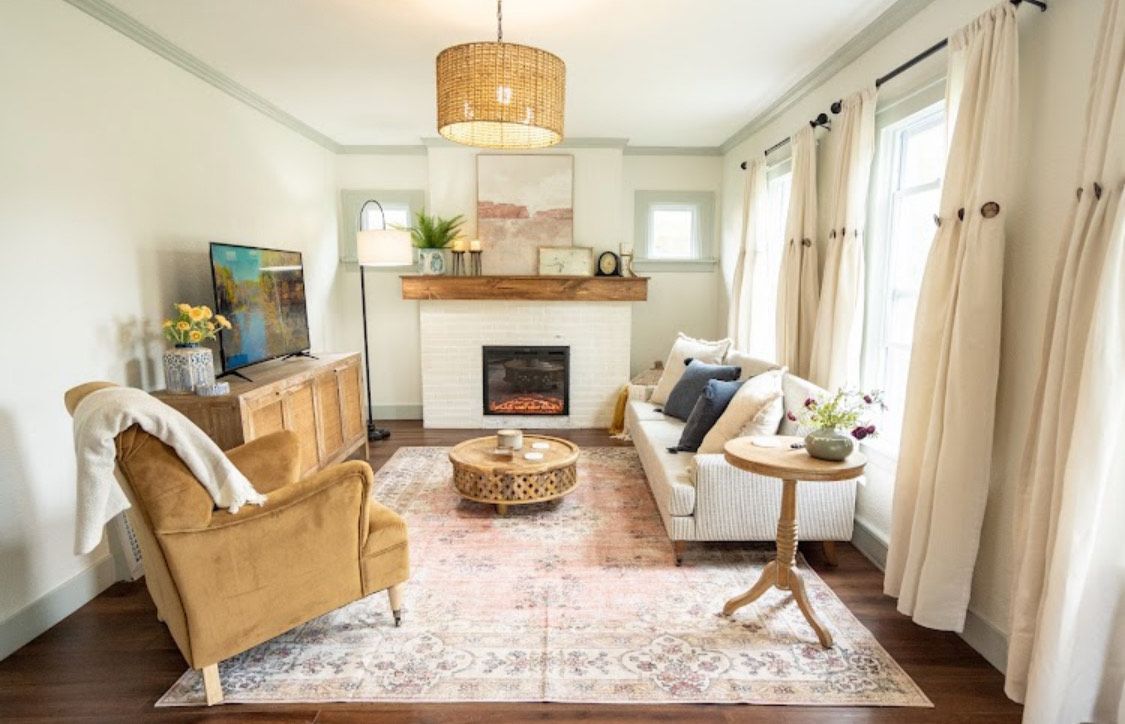 Living room with neutral tones, fireplace, and gold accents.