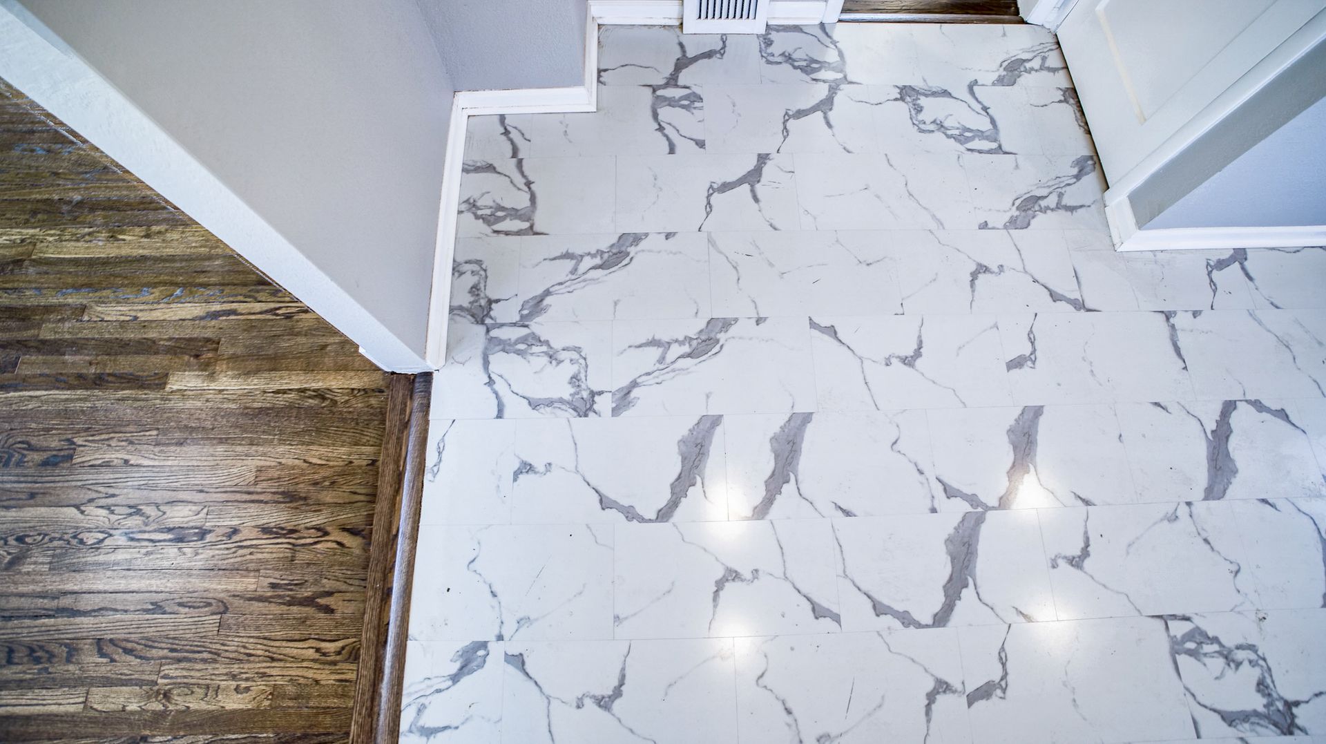 A white marble floor with a wooden floor in a room.