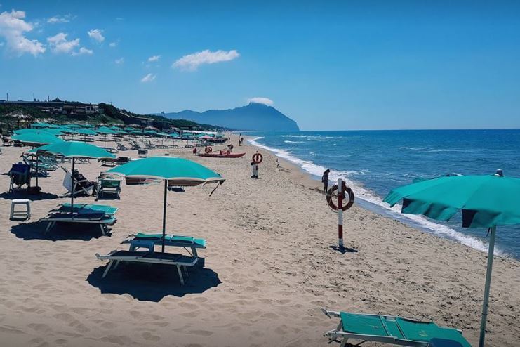 spiaggia con ombrelloni verdi