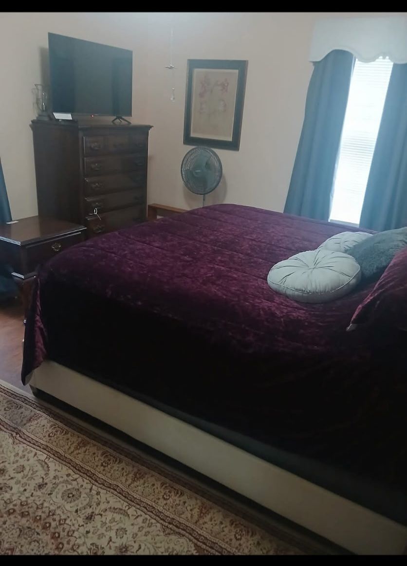 A building with a red roof, a porch, and stairs in front of a mountain.