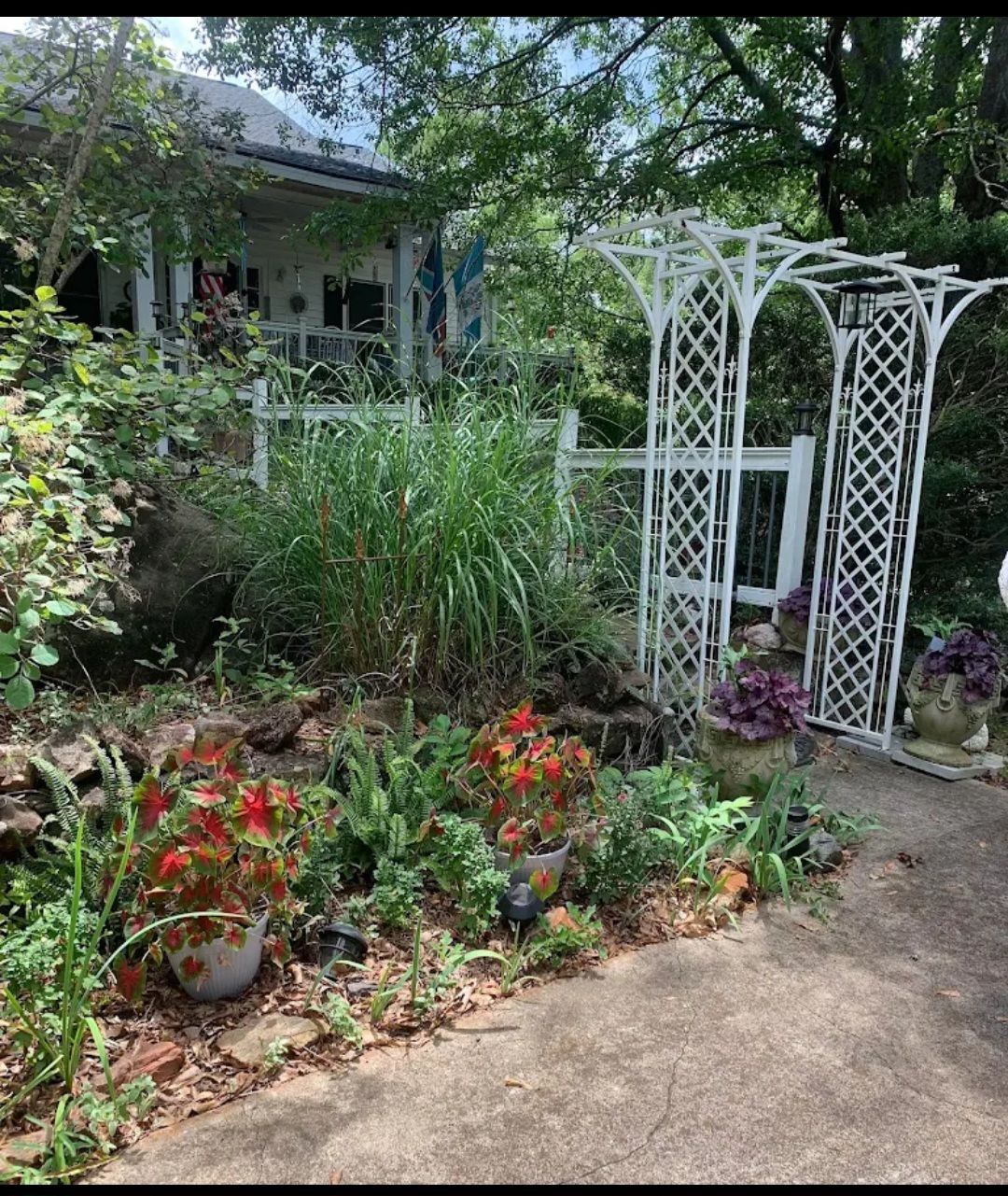 A TV sits atop a dark wooden dresser with drawers; animal figurines decorate the top. A fan sits beside the window.