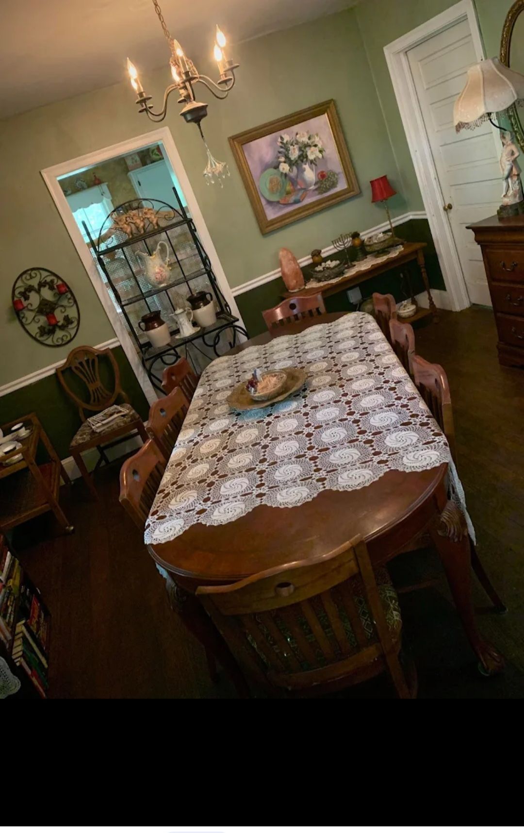 Dining room with dark wood furniture, sage walls, and a decorative cabinet.