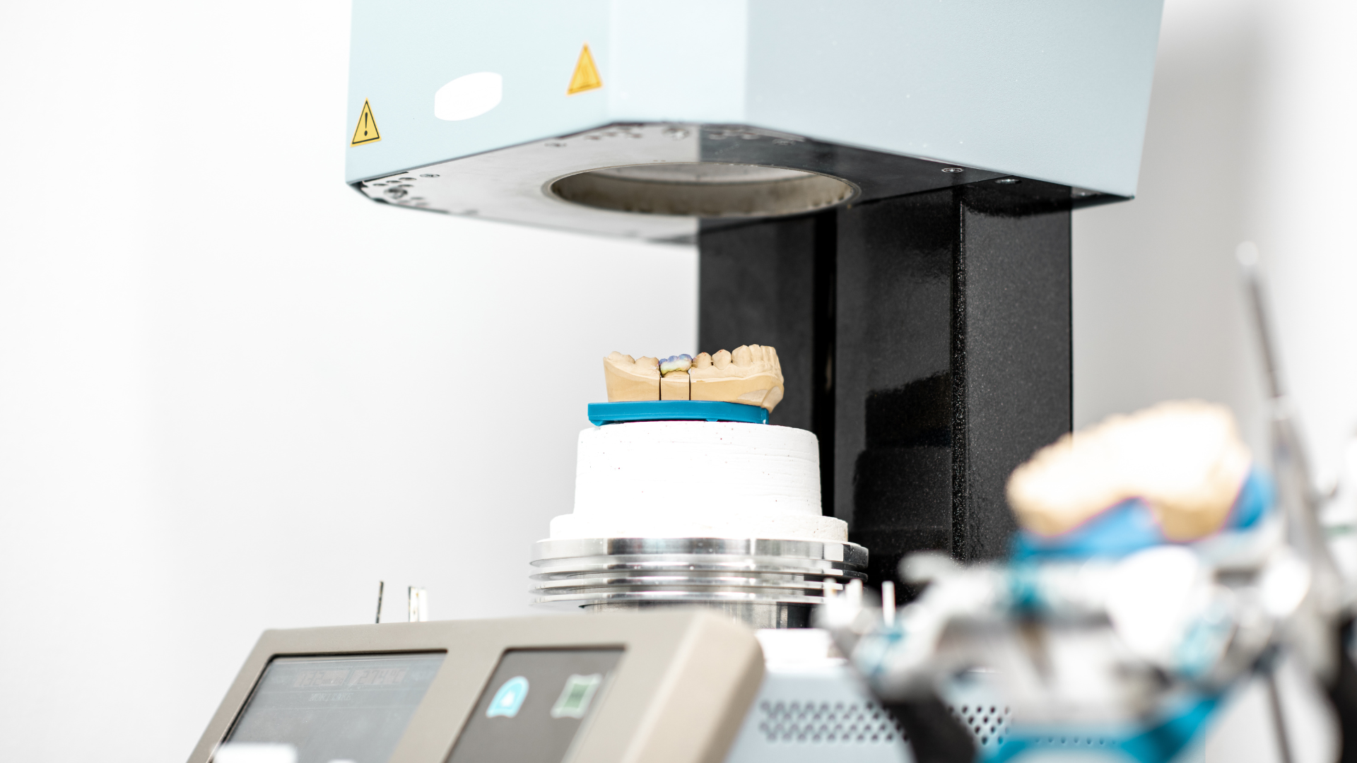 A dental machine with a model of a tooth on top of it.