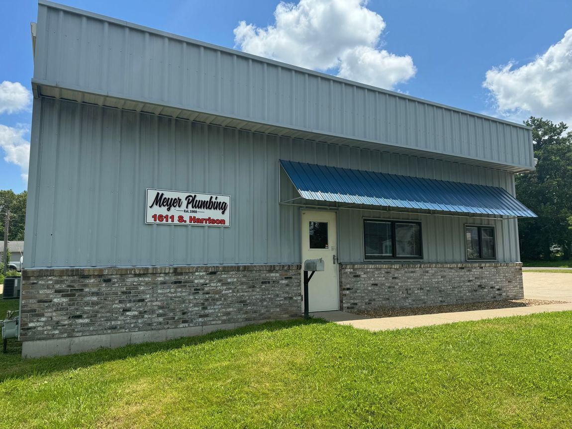 A large building with a blue awning and a sign on the side of it.