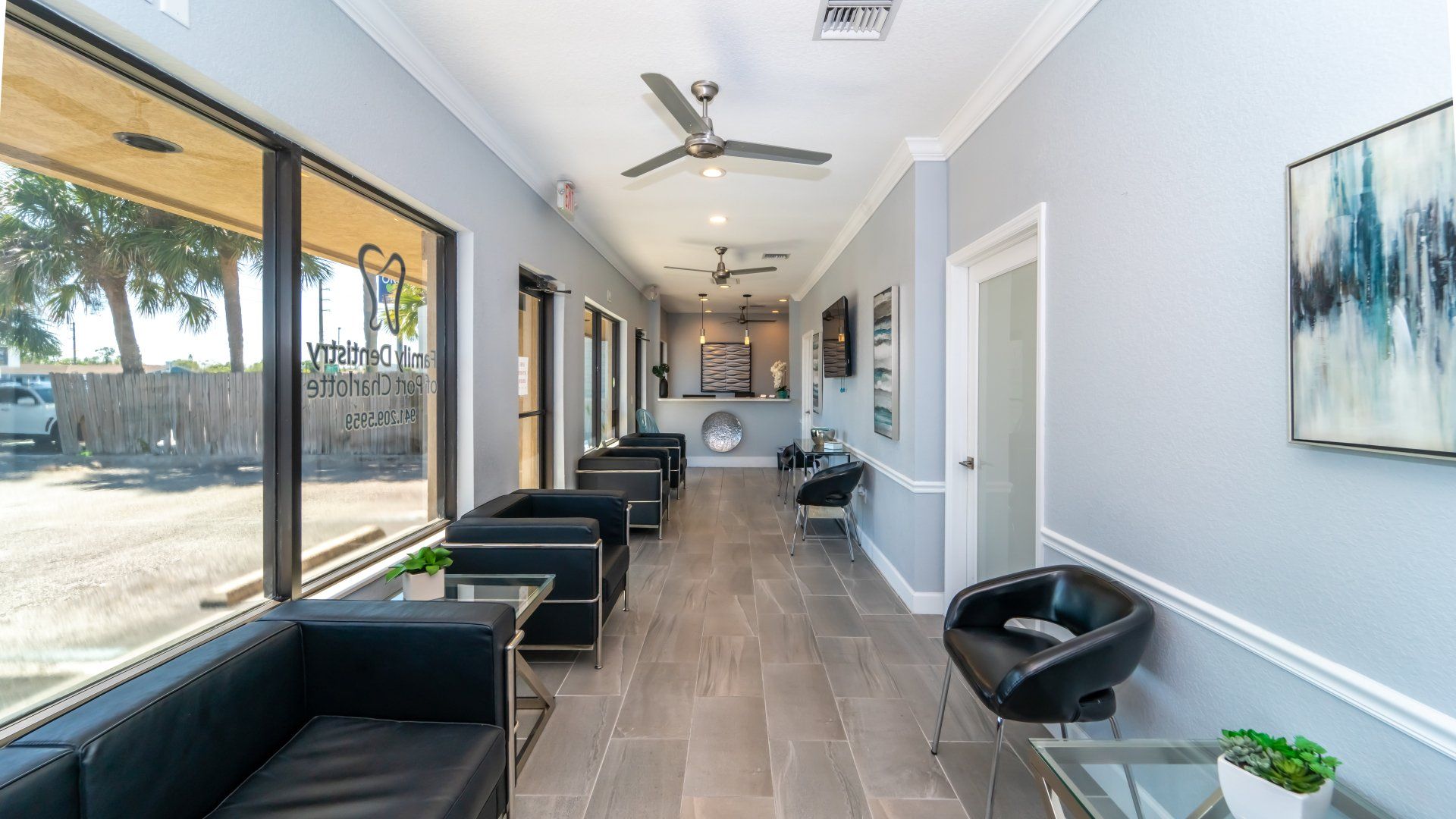 A long hallway with a lot of furniture and a ceiling fan.