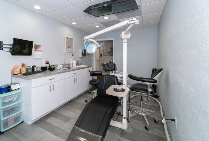 A dental office with a dental chair and a dental light.