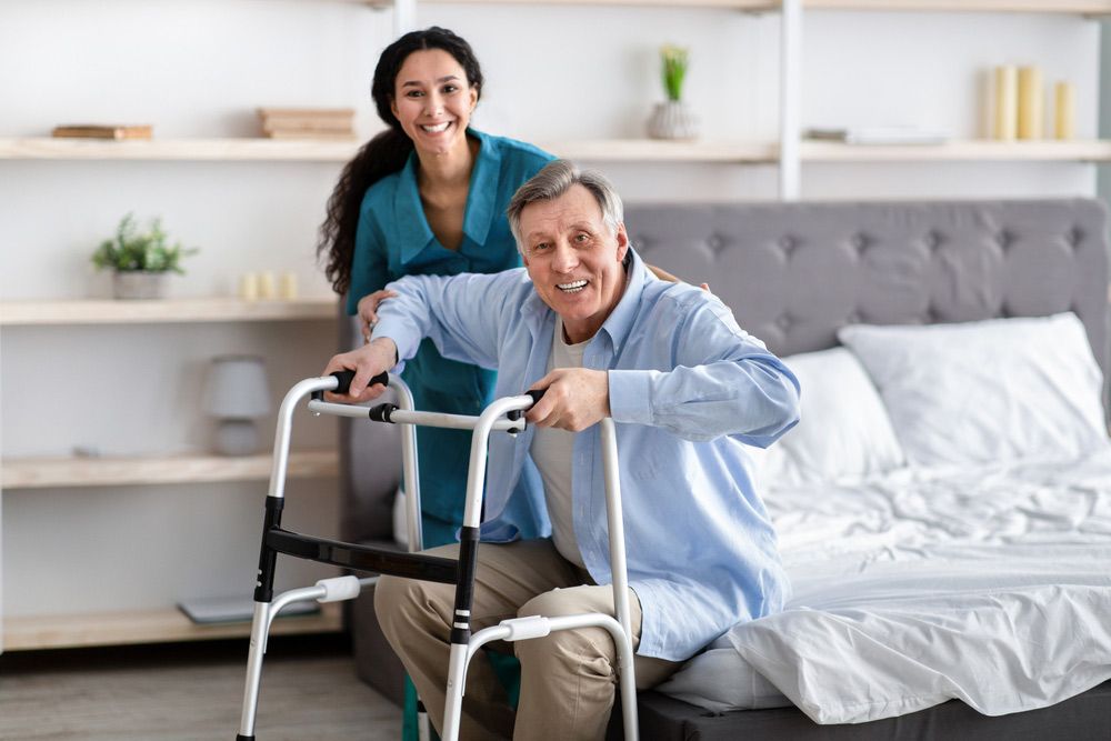 A Woman Is Helping An Elderly Man With A Walker — NQ Health In Bayview Heights, QLD
