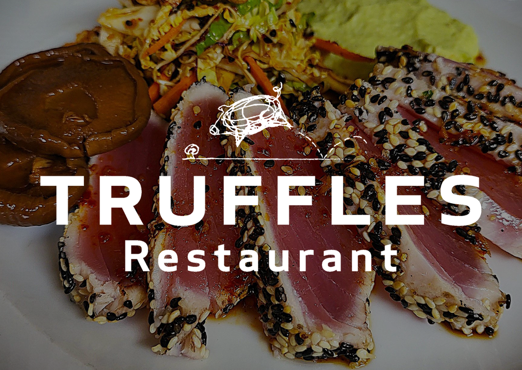 A white logo for a restaurant called truffles restaurant.