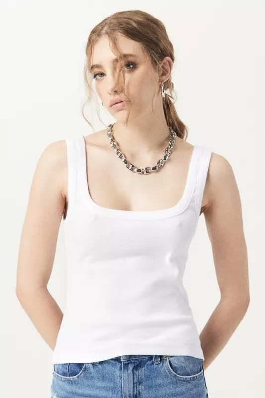 Una mujer lleva una camiseta blanca y un collar.