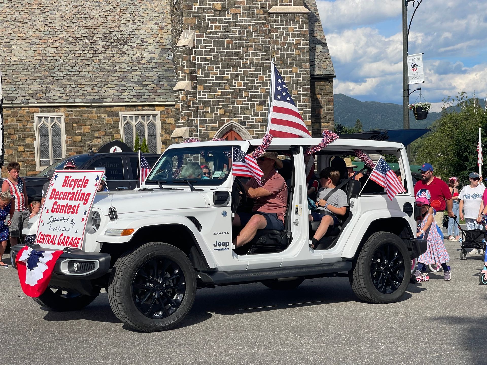 A vehicle decorated for July 4th is driving along the parade route on Main Street in Lake Placid.