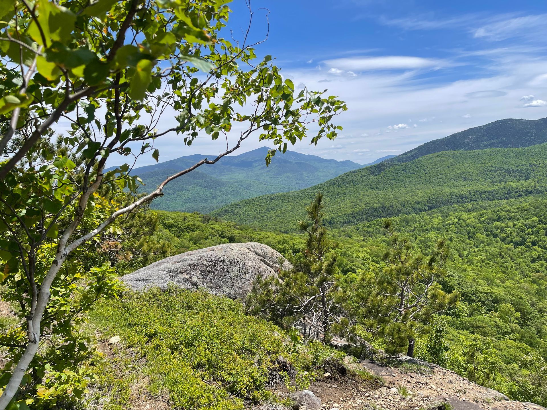 View of mountains and rocky ledge from a hiking path in NY's Adirondack Mountains