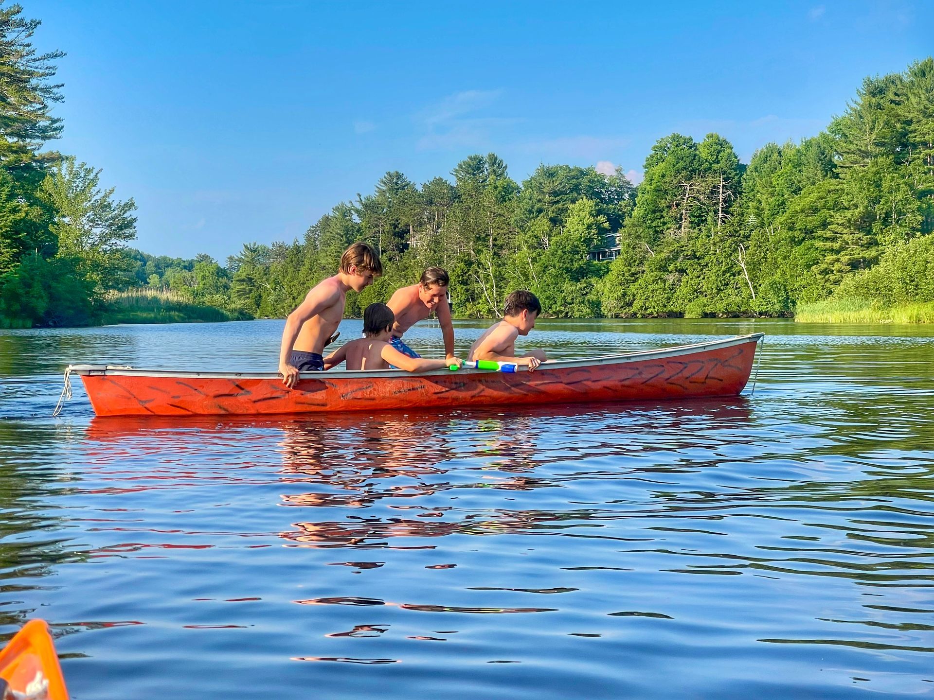 Three boys in a canoe at Wilmington Town Beach, Wilmington, NY