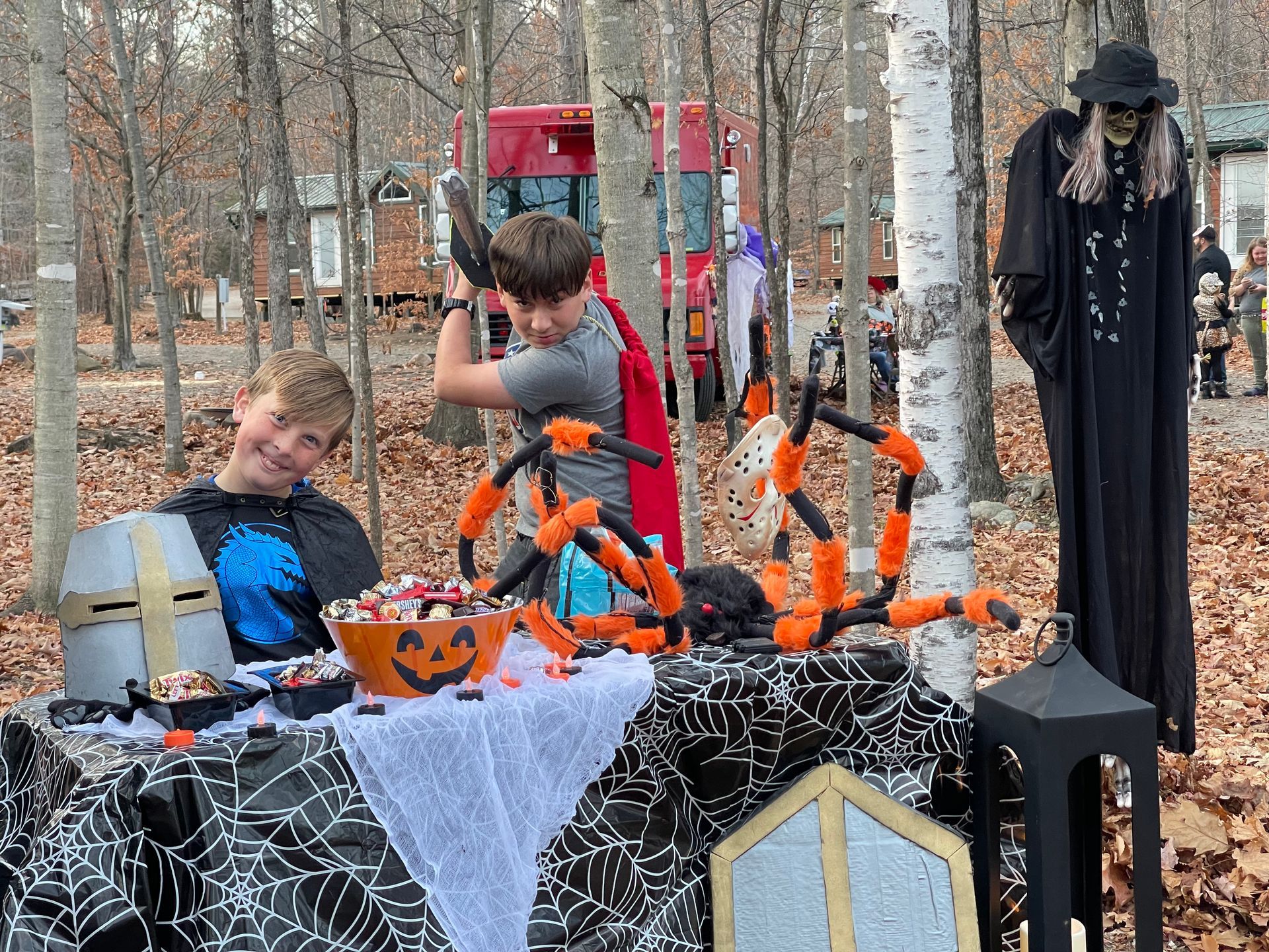 2 children at table with Halloween candies and decorations at the 2022 Trunk or Treat event