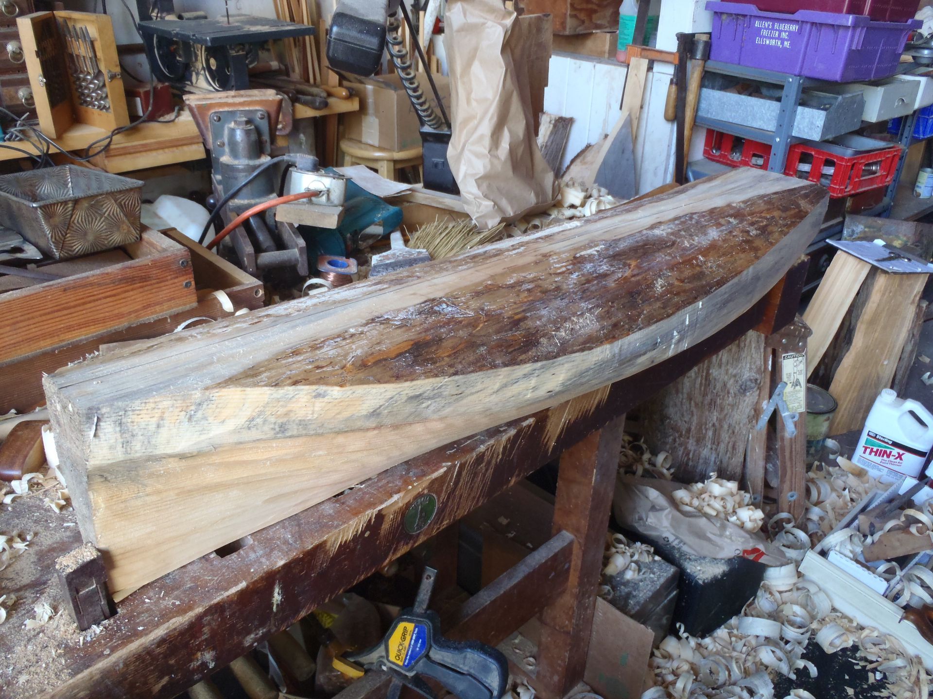 a large piece of wood sits on a workbench next to a bottle of timber cleaner