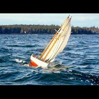 a small sailboat is floating on top of a large body of water .