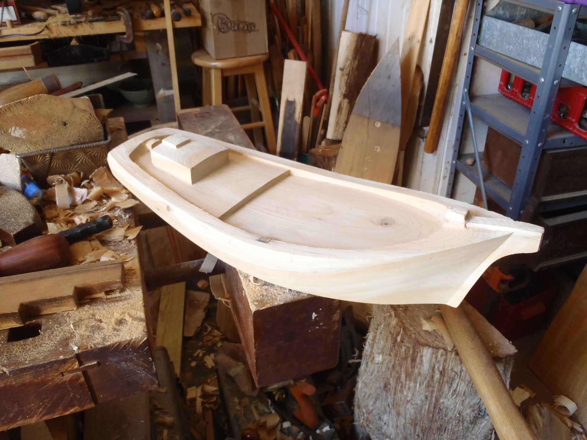 a wooden boat is being carved in a woodworking shop