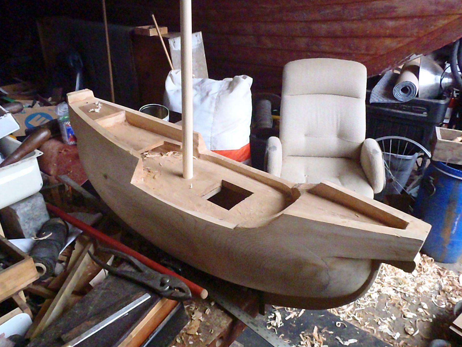 a white chair sits next to a wooden boat