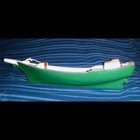 a green boat model is sitting on top of a blue surface .