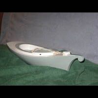 a white boat is sitting on top of a green blanket on a table .