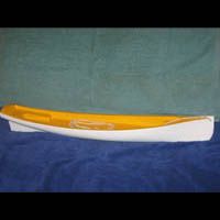 a yellow and white boat is sitting on top of a blue table .